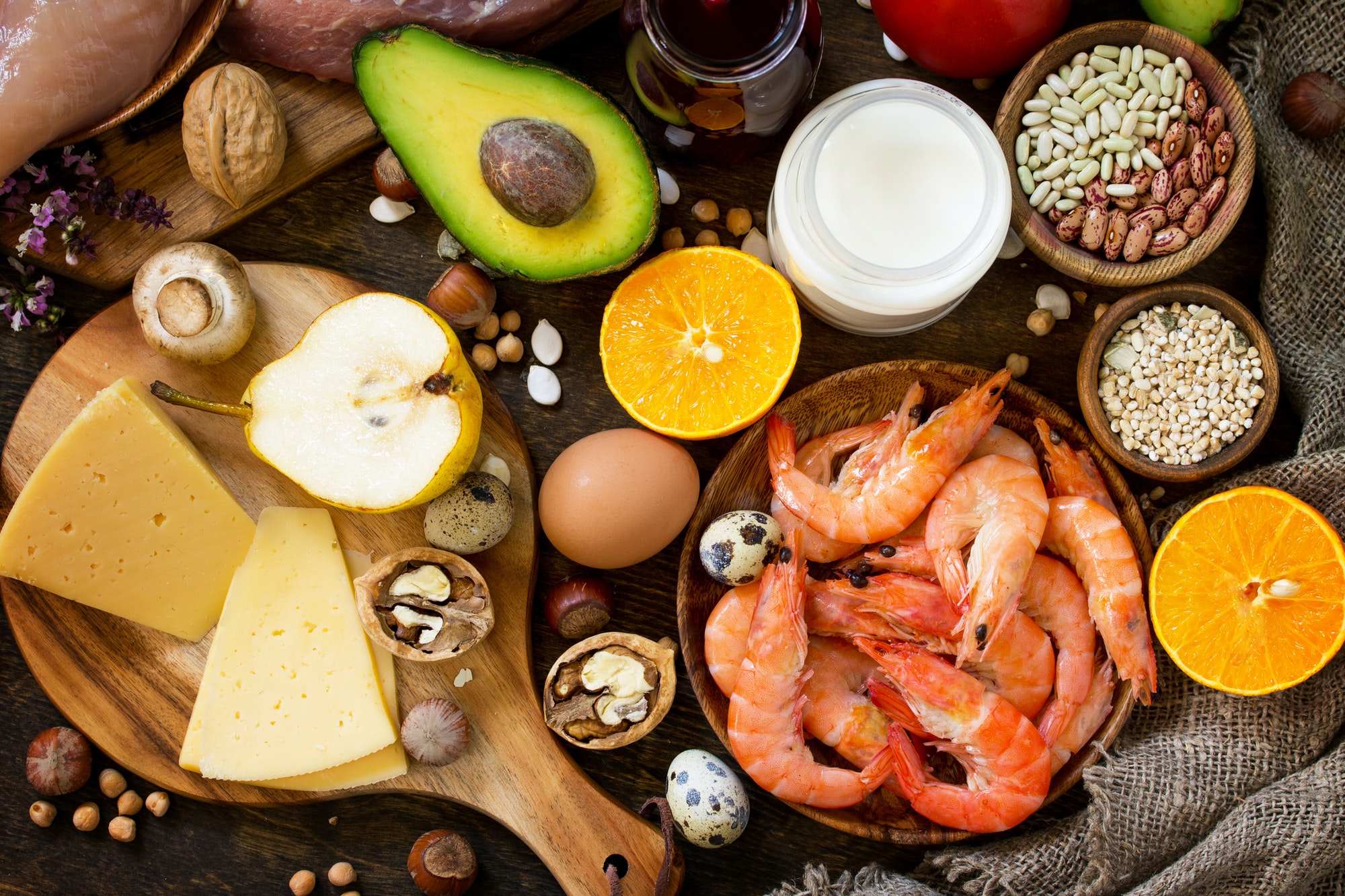 Protein foods, fruits, juice and vegetables on a rustic wooden background.